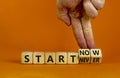 Start now or never symbol. Businessman turns wooden cubes and changes words `start never` to `start now`. Beautiful orange