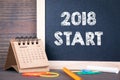 2018 start. paper calendar and chalkboard on a wooden table