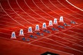Start of sprint race. Numbers and starting blocks on the red track. Athletics stadium. Track and field photo. Starting numbers on Royalty Free Stock Photo