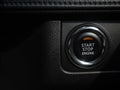 Start-Stop engine button with orange light on black car console background Royalty Free Stock Photo