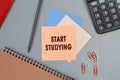 Start Studying - concept of text on sticky note. Closeup of a personal agenda. Top view. Office concept Royalty Free Stock Photo