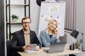 Start up business team on meeting in modern office interior, working on laptop and tablet. A young woman and a man are sitting at Royalty Free Stock Photo