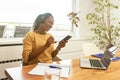 Start up businesswoman, African American woman wearing headphones music and holding mobile phone using bluetooth listening music Royalty Free Stock Photo