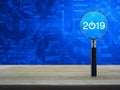 2019 start up flat icon with magnifying glass on wooden table over currency symbol blue tone background, Business happy new year