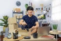 Start up small business asian man young entrepreneur preparing parcels packing cardboard box for delivery process for send order