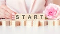 start - words from wooden blocks with letters, pink background Royalty Free Stock Photo