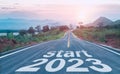 Start 2023 written on highway road in the middle of empty asphalt road of asphalt road at sunset.Concept of planning and challenge Royalty Free Stock Photo