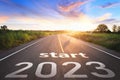 Start 2023 written on highway road in the middle of empty asphalt road of asphalt road at sunset.Concept of planning and challenge Royalty Free Stock Photo