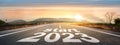 Start 2023 written on highway road in the middle of empty asphalt road of asphalt road at sunset.Concept of planning and challenge Royalty Free Stock Photo