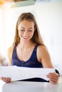 Start your day with good news. a young woman reading paperwork at home. Royalty Free Stock Photo