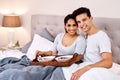 Start your day with love and a good meal. Shot of a happy young couple having breakfast in bed together. Royalty Free Stock Photo