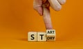 Start your story symbol. Businessman turns a wooden cube and changes the word `story` to `start`. Beautiful orange background,