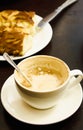 started cup of coffee and sliced cake on a black table Royalty Free Stock Photo