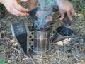 Experienced master bee keeper in his apiary setting a fire in a bee smoker.