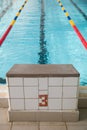 Starting blocks and lanes in a swimming pool. Edge of indoors sport swimming pool. Starting platforms with number 3 Royalty Free Stock Photo