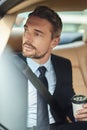 Starting the day with coffee. a handsome businessman drinking coffee while driving into work. Royalty Free Stock Photo