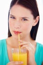 Starting the day with a fresh glass of orange juice. Portrait of an attractive young woman sipping orange juice through Royalty Free Stock Photo