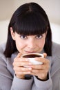 Starting her day with a fresh, strong cup of coffee. Cropped shot of a beautiful young woman enjoying a cup of coffee in Royalty Free Stock Photo