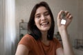 Overjoyed young female shoot selfie holding keys from new home