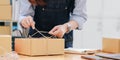 Starting small business, SME owner, female entrepreneurs are using the rope to tie boxes to pack products Order online to prepare