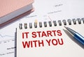 IT STARTS WITH YOU. Text written on notepad with pen on financial documents Royalty Free Stock Photo