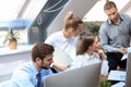 Startup business team on meeting in modern bright office interior brainstorming, working on tablet and PC computers Royalty Free Stock Photo