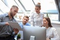 Startup business team on meeting in modern bright office interior brainstorming, working on tablet and PC computers Royalty Free Stock Photo