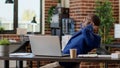 Startup employee relaxing laid back on desk chair in office