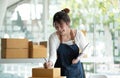 Startup happy Asian woman business owner works with a box at home, prepare parcel delivery SME supply chain, procurement, package