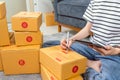 Startup small business concept, young woman owner working and packing on the box to customer at the sofa in home office. Royalty Free Stock Photo