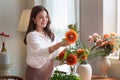 Startup, small business, flower shop. Young pretty florist putting a flower on a vase