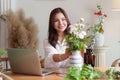 Startup, small business, flower shop. Young pretty florist putting a flower on a vase