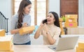 Startup small business owner working with computer at workplace. Freelance two woman seller check product order. Packing goods for Royalty Free Stock Photo