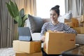 Startup small business, Young woman checking order on digital computer and preparing parcel boxes for delivery. Royalty Free Stock Photo