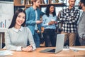 Startupers working together at office woman sitting at table with laptop looking camera joyful Royalty Free Stock Photo