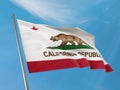 State flag of California flag on a pole waving. California realistic flag waving against clean blue sky. Royalty Free Stock Photo