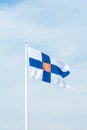State flag of Finland with national coat of arms against blue sky Royalty Free Stock Photo