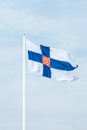 State flag of Finland with national coat of arms against blue sky Royalty Free Stock Photo