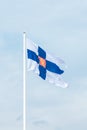 State flag of Finland with national coat of arms against blue sky Royalty Free Stock Photo