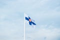 State flag of Finland with national coat of arms against blue sky Royalty Free Stock Photo