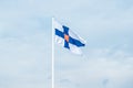 State flag of Finland with national coat of arms against blue sky Royalty Free Stock Photo