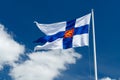 State flag of Finland with national coat of arms against blue sky on the wind Royalty Free Stock Photo