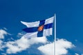 State flag of Finland with national coat of arms against blue sky on the wind Royalty Free Stock Photo