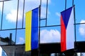 State flags of the Czech Republic and Ukraine near modern building in Prague. Czechs oppose Russia war against Ukraine, stand with