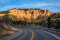 State Road 14 leads toward cliff of orange and red rock towers and hoodoos Royalty Free Stock Photo