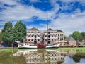 Stately monumental mansion with moored boat mirrored in a canal, Gouda, Netherlands
