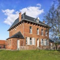 Stately parsonage againts a blue sky with dramatic clouds, Ravels, Belgium