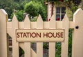 Station House sign on painted wooden gate leading. English country garden style scene