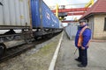 Station master watching a freight train passing by. Railway station facilities. Royalty Free Stock Photo