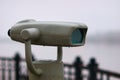 Stationary binoculars on the embankment. Raindrops on the surface.